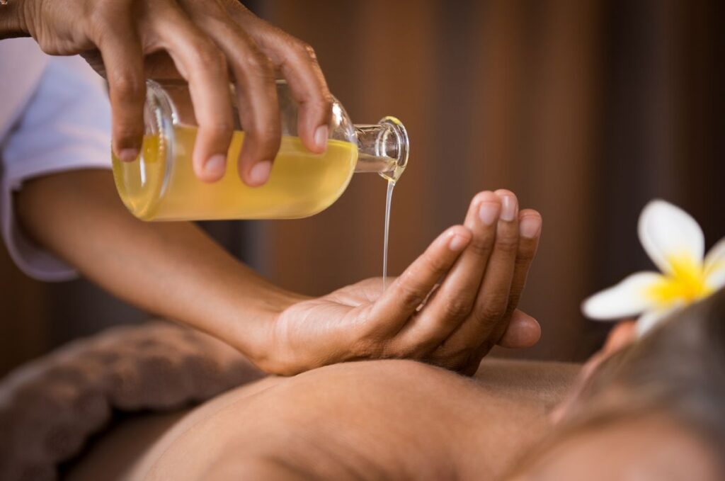 Une masseuse professionnelle fait couleur de l'huile de massage dans sa main