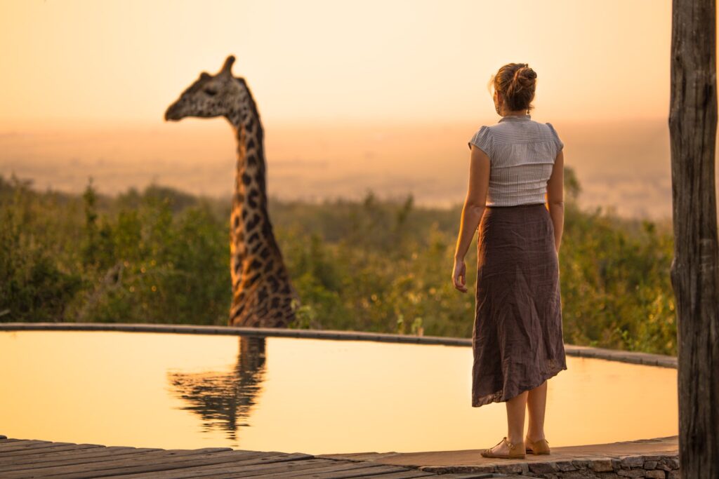 Femme habillée pour un safari au Botswana devant une girafe